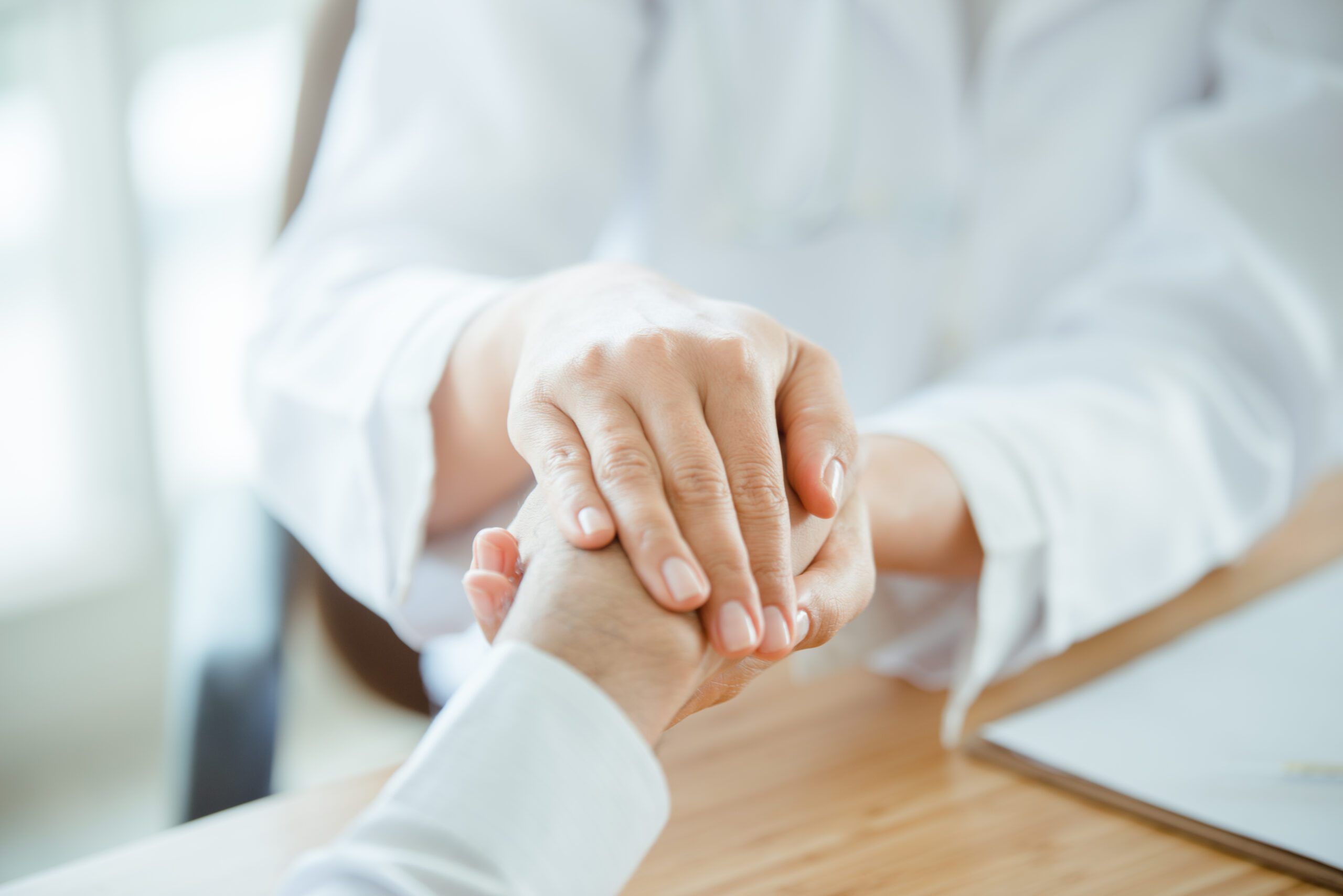 The doctor handles her patient's hand. To be grateful